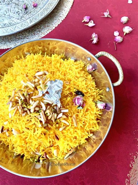 A Bowl Filled With Yellow Rice And Nuts On Top Of A Red Table Cloth