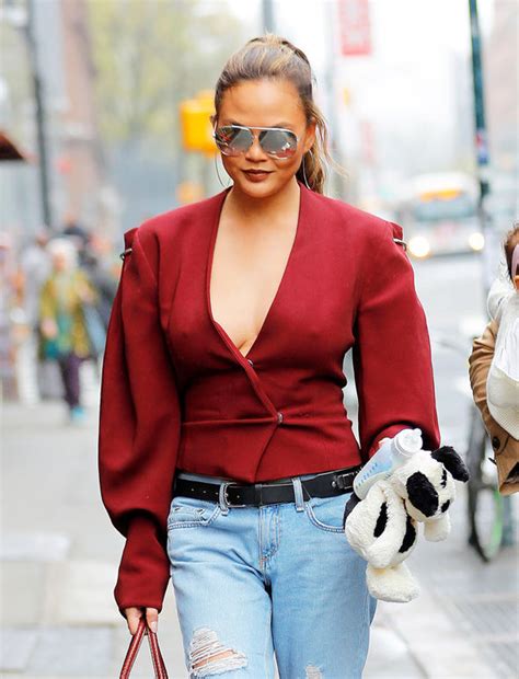 chrissy teigen teases nipples as she flashes extreme cleavage in plunging scarlet top