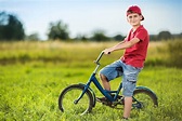 Premium Photo | Young boy riding a bicycle on a field