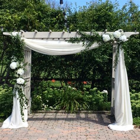 White Fabric And Greenery On A Wooden Wedding Arbor Wedding Gazebo