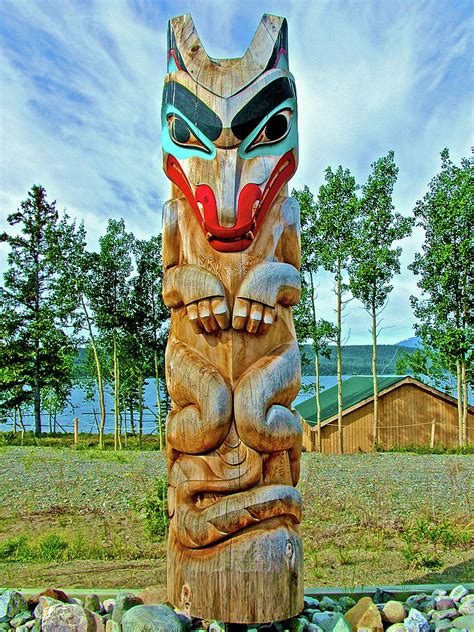 A tall wooden pole with symbols cut or painted on it that is part of the tradition of the native…. Teslin Lake And A Totem Pole At Teslin Tlingit Heritage ...