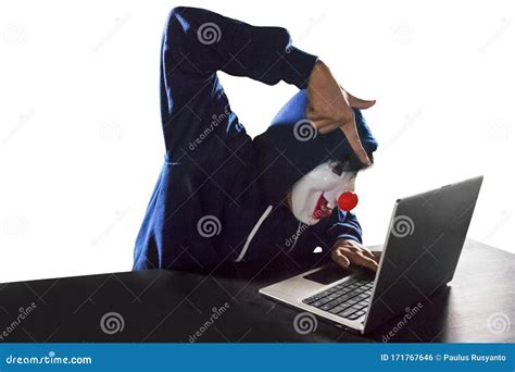 Hacker Wearing Clown Mask Using A Laptop Over White Stock Photo Image
