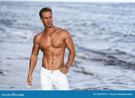 Hombre Hermoso Con El Torso Muscular Desnudo En La Playa Blanca De La