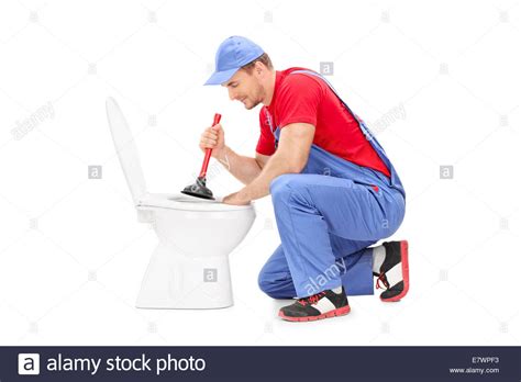 Male Plumber Working On A Toilet With A Plunger Isolated On White