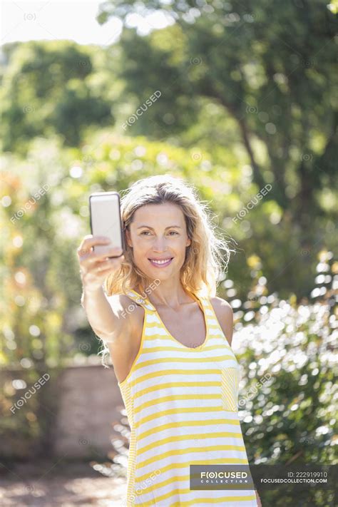 Smiling Mature Woman Taking Selfie In Summer Garden Happiness Caucasian Ethnicity Stock