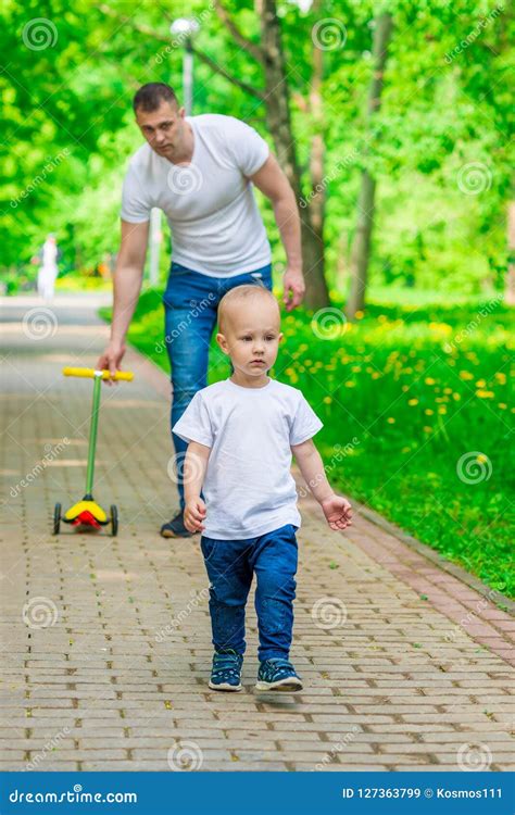 El Padre Y El Hijo En Un Paseo En Un Parque Del Verano Pasan Imagen De
