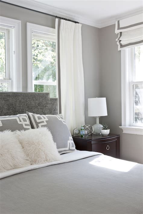 White doors are featured leading out to an outdoor patio, while within the room a dark accent wall behind the bed helps to deflect some of the natural light and create a warm and cozy feel. Gray Bedroom - Transitional - bedroom - Roxanne Lumme ...