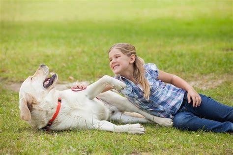 Niña Feliz Jugando Con Perro Mascota En El Parque Foto Premium
