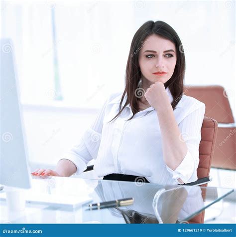 Serious Business Woman Sitting At The Desk In The Office Stock Image