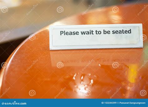 Please Wait To Seated Sign On Table Top At Restaurant Stock Image