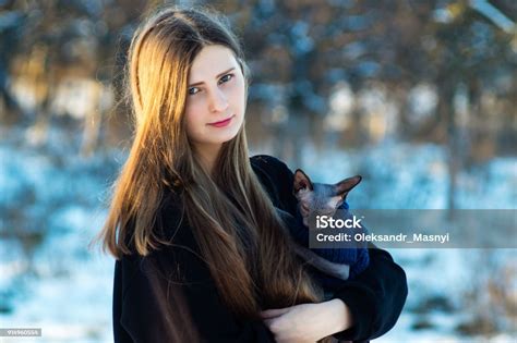 ung vacker flicka med hennes fitta i famnen i vinterparken på en dag katt rasen swiss foton och