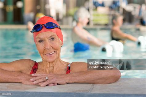 Caucasian Woman Leaning On Edge Of Swimming Pool High Res Stock Photo