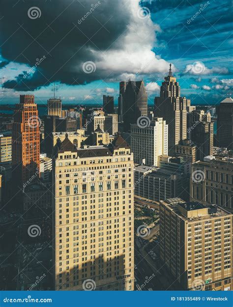 Vertical Picture Of Buildings Under A Cloudy Sky And Sunlight In