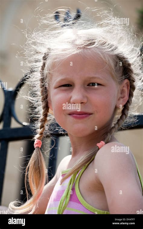 Closeup Portrait Of Smiling Little Girl With Long Blonde Pigtails