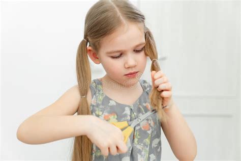 Little Girl Cutting Hair To Herself With Scissors Stock Photo Image