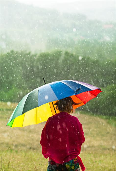 Woman With Colorful Umbrella Enjoying Rain In The Meadow By Stocksy