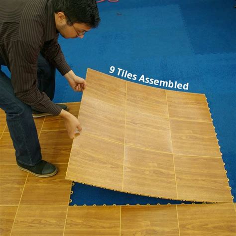 A Man Is Working On Wood Flooring With The Words9 Tiles Assembled