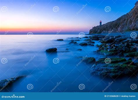 Beautiful Seascape With Lighthouse At Sunset Mountains And The Sea
