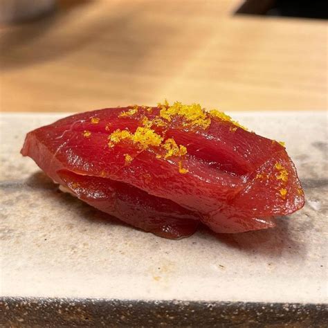 A Piece Of Raw Tuna On A Plate With Mustard Sprinkled On The Side