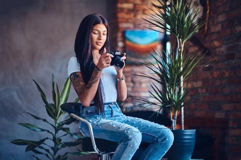 Premium Photo Tattooed Brunette Amateur Female Photographer Takes Pictures In A Room With Loft