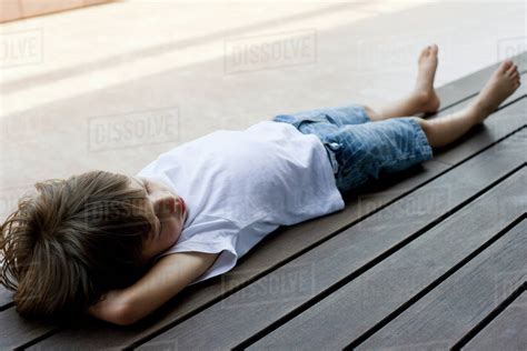 Little Boy Lying On Back On Deck Stock Photo Dissolve