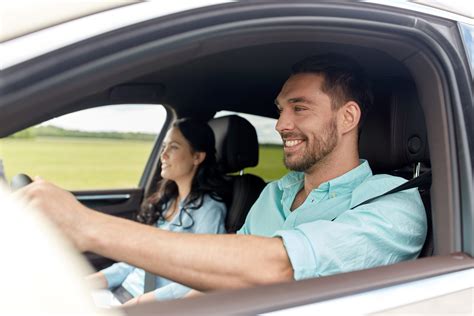 Happy Man And Woman Driving In Car Laureate Insurance Partners