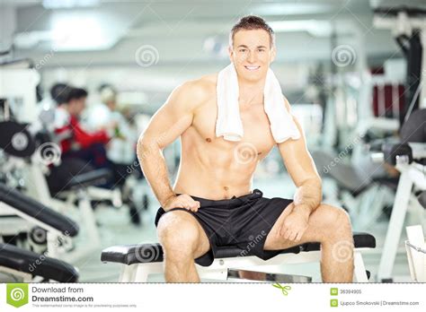 Muscular Young Guy Sitting On A Bench In A Gym Stock Image Image Of