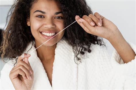 Young African American Woman Uses Mint Floss To Clean Her Teeth Stock