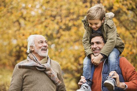 Three Generations Of Men Smiling In Park Stock Photo