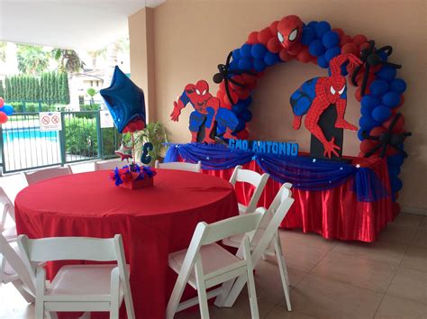 A Red Table Topped With Balloons And Spiderman Decorations