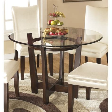 This new classic dining table set comes with four matching solid wood dining chairs. Ashley Furniture Charrell Glass Round Dining Table in Medium Brown - D357-15