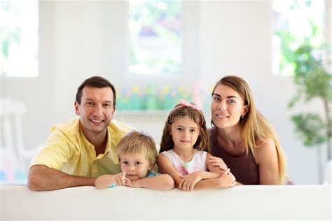 Familia Feliz En Casa Padres E Hijos En El Sofá Imagen De Archivo Imagen De Poco Hipoteca