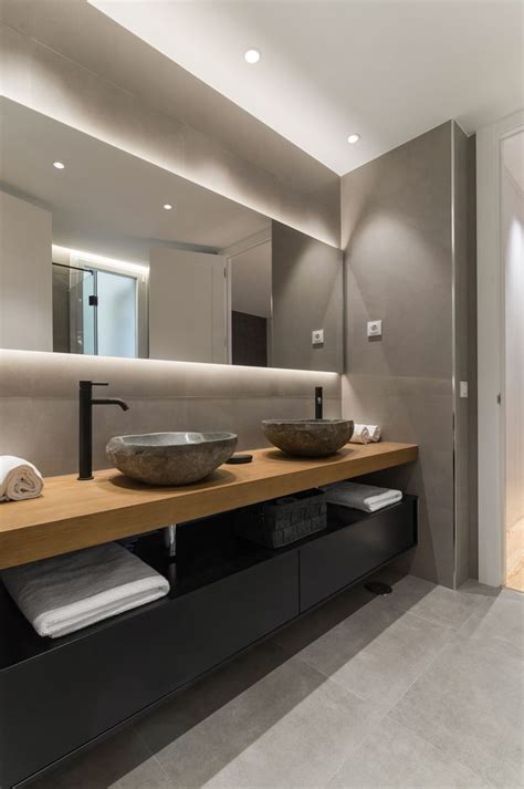 A Modern Bathroom With Two Sinks And Mirrors
