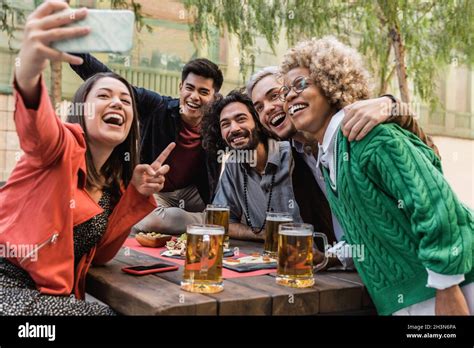 Young Multiracial People Having Fun Taking A Selfie With Mobile Phone Drinking Beer At Brewery