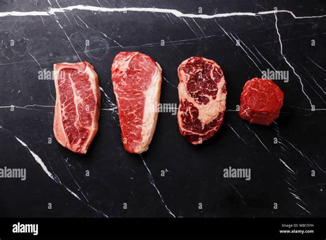 variety of raw black angus prime meat steaks blade on bone striploin rib eye tenderloin