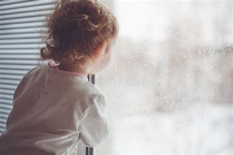 Un Enfant Regarde La Fenêtre Photo Stock Image Du Chéri Verticale