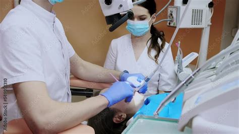 Stockvideo Dentist With Assistant Under Microscope Treats The Patients