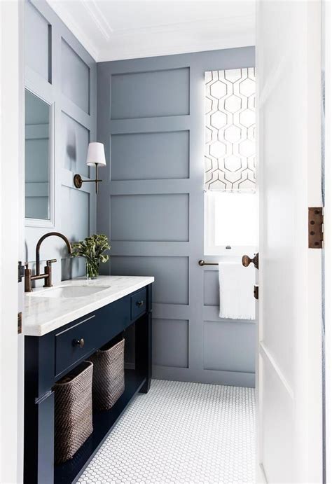 Your email address will not be published. A navy blue vanity contrasts with the muted wall panelling ...
