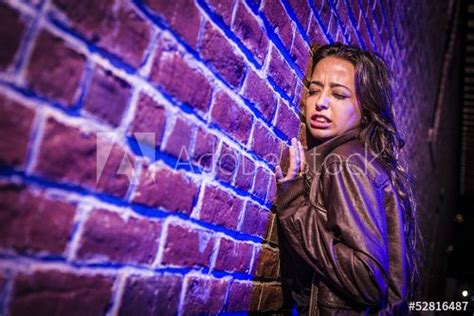 Frightened Pretty Young Woman Against Brick Wall At Night Brick Wall