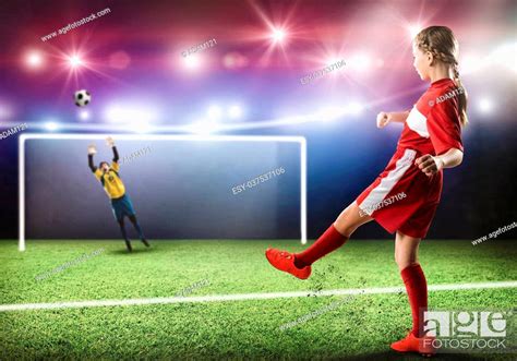 Kid Girl Football Player On Stadium Kicking Ball To Gates Stock Photo