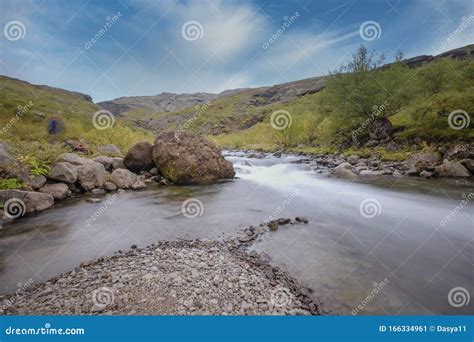 Iceland A Big Rock And Little Rocks In A Fast Flowing River With A