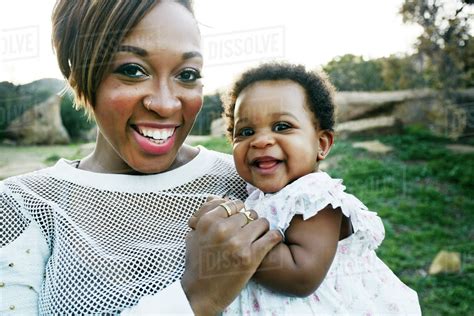 Black Mother Holding Baby Daughter In Field Stock Photo Dissolve