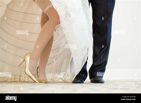 Legs Of The Groom In Black Shoes And Trousers And Brides In Stockings