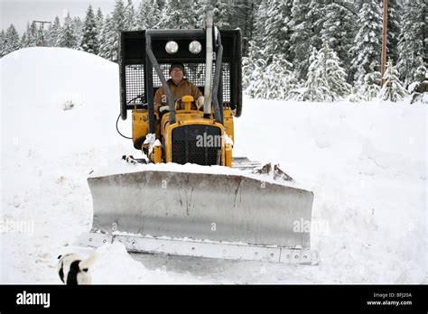 Senior Citizen Plowing Snow In A Bulldozer Excavator Stock Photo Alamy