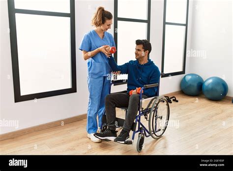 Ein Junger Behinderter Mann Der Auf Dem Rollstuhl Sitzt Macht In Der Klinik Mit Kurzhanteln