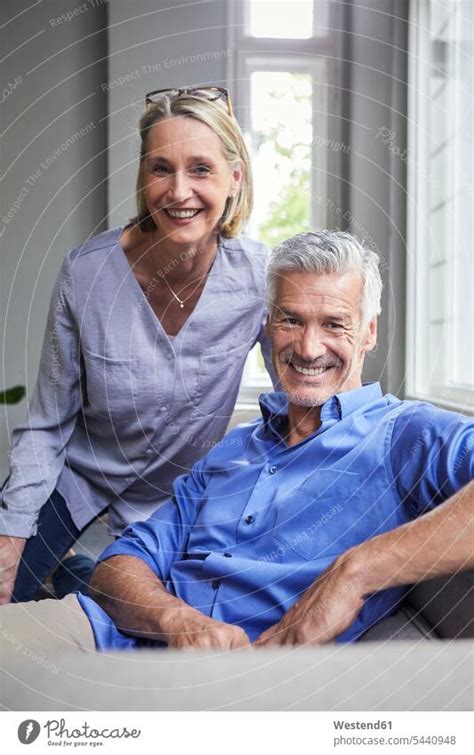 Portrait Of Smiling Mature Couple On Couch At Home A Royalty Free