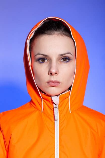 Premium Photo Brunette Woman In Orange Jacket Blue Background High
