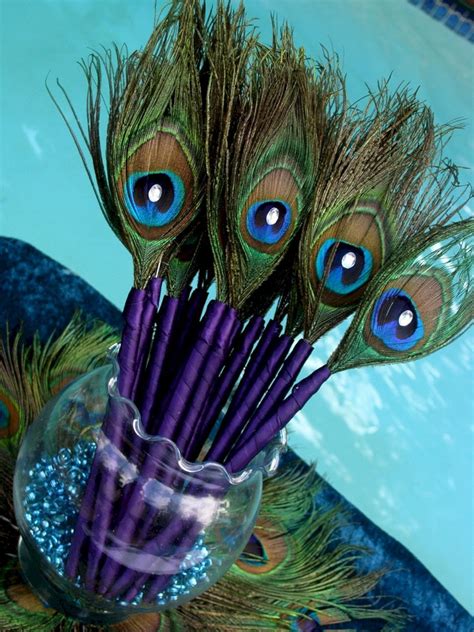 a vase filled with purple and green feathers on top of a table next to a swimming pool