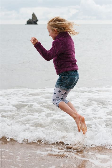 A Little Girl Jumping In The Sea By Stocksy Contributor Helen