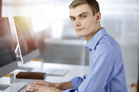 Young Successful Businessman Works With Computer Sitting At The Desk